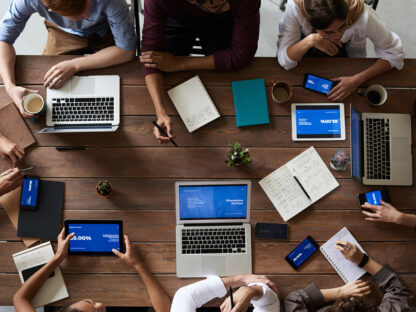 top view photo of people near wooden table with laptops