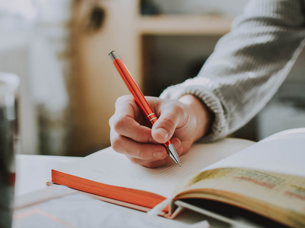 person holding orange pen