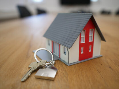 photo of a wooden house model and keys