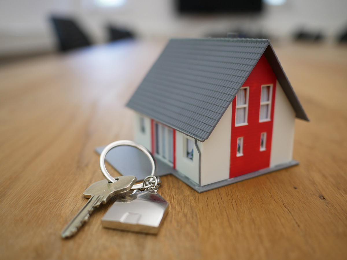photo of a wooden house model and keys