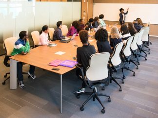A group of people training for their business in a classroom.