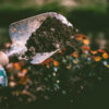 Person Digging on Soil Using Garden Shovel